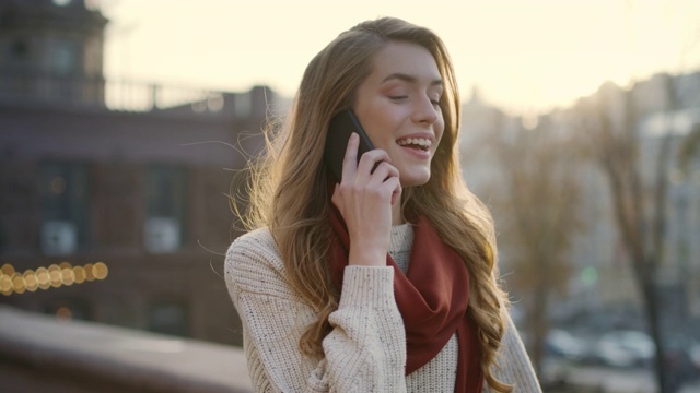 甜美的女人在户外打电话。快乐女孩在街上用手机。视频素材