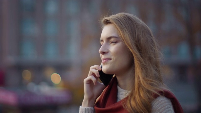 快乐的女孩在街上打电话。带着手机出门的时髦女人。视频素材