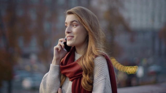 带着手机散步的漂亮女人。快乐的女孩在户外打电话聊天。视频素材