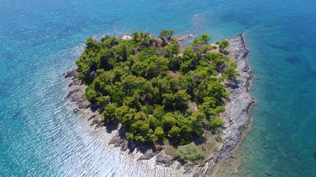 热带异国情调的岛屿，岩石海岸和绿树在蓝色的海洋。鸟瞰图视频素材