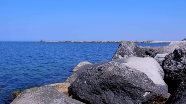 海景，巨石，码头和蓝色的水在晴朗的日子。视频素材