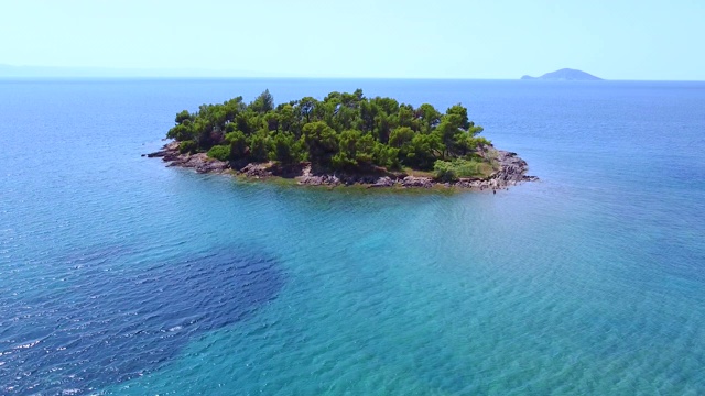 与孤独的热带岛屿飞过蓝色清澈的海洋。异国风情的旅游目的地视频素材