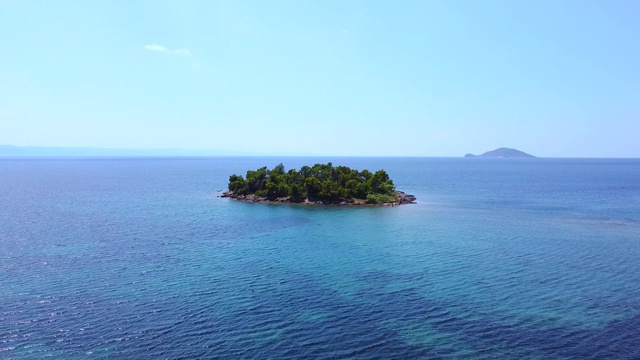 与孤独的热带岛屿飞过蓝色清澈的海洋。异国风情的旅游目的地视频素材