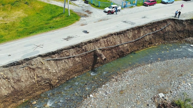 鸟瞰被洪水冲毁的村庄道路。被山河冲走的柏油路被毁了。视频素材