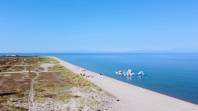 长长的宽阔的海滩，白色的沙滩和好玩的海水公园。暑假的概念。鸟瞰图视频素材