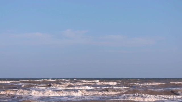 日落时海浪冲向海滩。慢动作海洋白色的水海浪拍击。视频素材