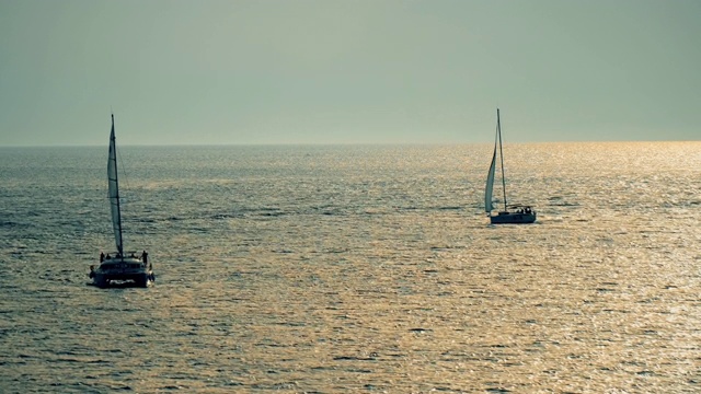 浪漫的画面:游艇在夕阳的余晖中飘向远方的地平线视频素材