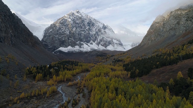 飞越山谷秋树和河流之间的高山。无人机视频视频素材