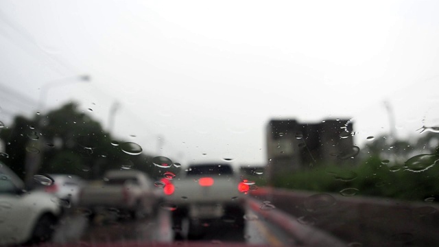 汽车镜子上的雨滴特写。窗上有水滴凝结。挡风玻璃刮水器在擦拭汽车前后视镜上的水滴。视频素材
