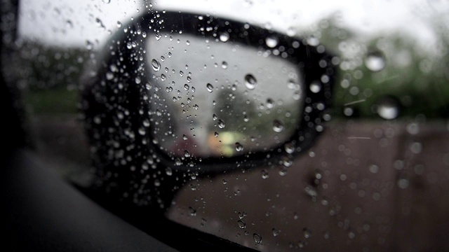汽车镜子上的雨滴特写。窗上有水滴凝结。视频素材