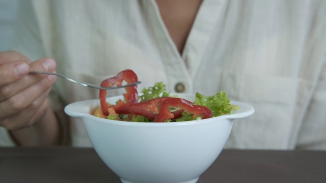 女人吃新鲜的素食沙拉。视频素材