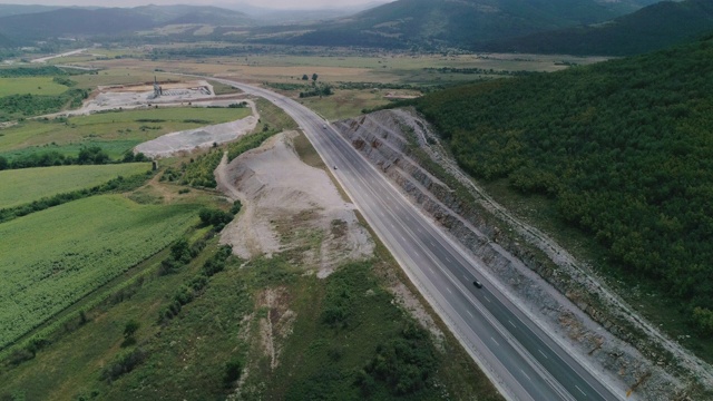 修建新的公路。高速公路建筑工地上空鸟瞰图，俯视图，城市景观。全球商业、建筑、运输和工业。视频素材