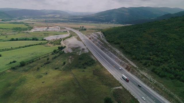 修建新的公路。高速公路建筑工地上空鸟瞰图，俯视图，城市景观。全球商业、建筑、运输和工业。视频素材