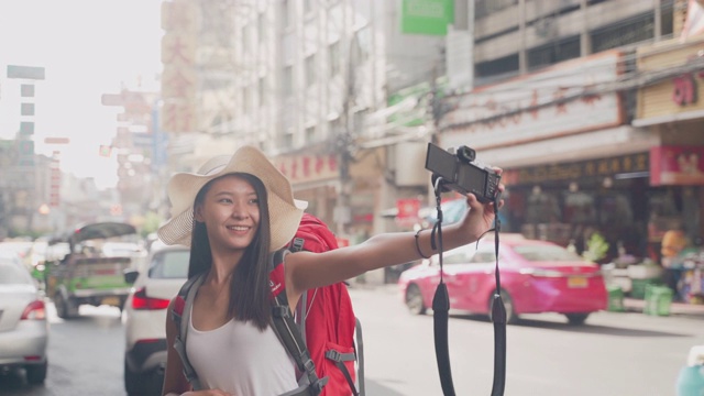 女性博主使用智能手机拍摄照片和视频。视频旅游视频博客的订户和渠道在餐厅。视频素材