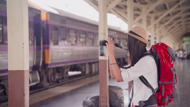 亚洲女摄影师，年龄20-30岁。“桥背包”旅游博主使用相机在泰国徒步拍摄在线旅游频道的视频片段。视频素材