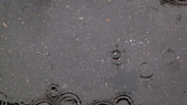 近距离观察雨滴落在街道上，雨滴落在被淹没的道路上视频素材