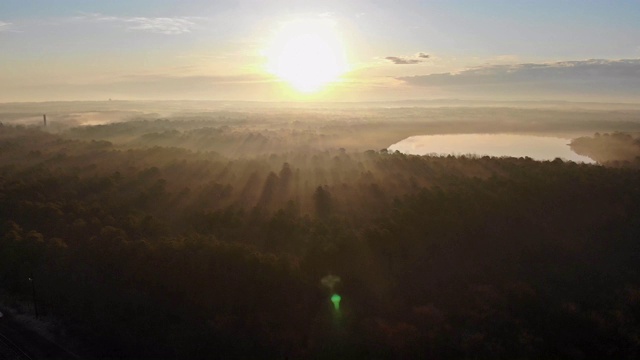 风景朦胧的全景，梦幻梦幻的日出在雾霭之上。俯瞰下面雾蒙蒙的森林山丘。视频素材