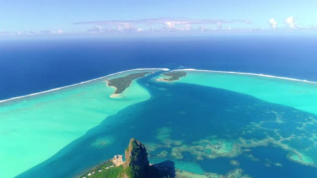 法属波利尼西亚毛皮提岛的火山。在蓝天鸟瞰图下，我们可以看到太平洋旁边的青绿色泻湖视频素材