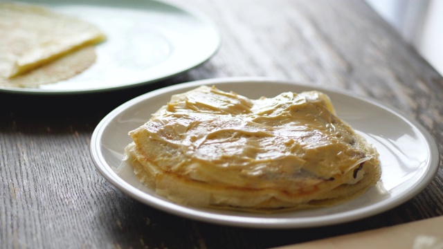 在可丽饼上涂上奶油。视频素材