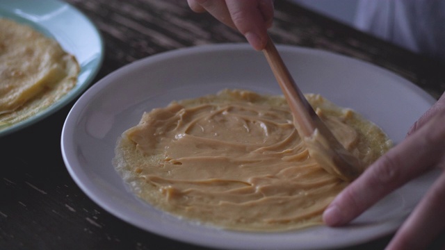 在可丽饼上涂上奶油。视频素材