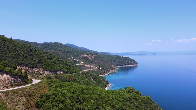 在海边的山上有路，可以看到绿松石清澈的大海。鸟瞰图视频素材