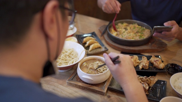 两名男子戴着面具在日本餐厅用餐，这是新常态视频素材