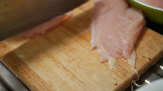 在厨房的砧板上亲手切鸡肉，生活理念。视频素材