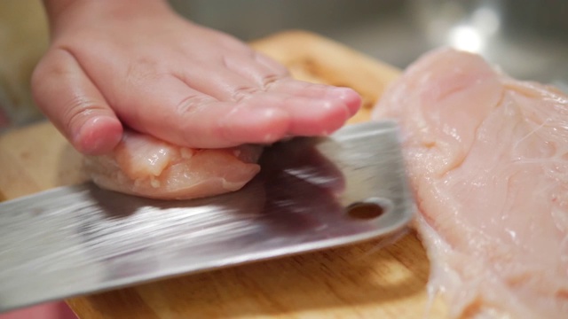 在厨房的砧板上亲手切鸡肉，生活理念。视频素材