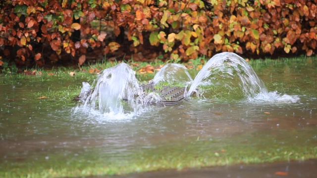 英国坎布里亚郡安布尔赛德市的排水沟里，洪水泛滥，水从井盖上冲了出来。视频素材