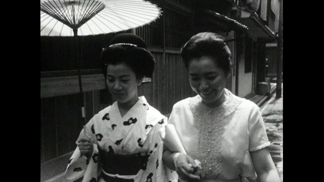 日本妇女撑着伞走在街上;1966视频素材