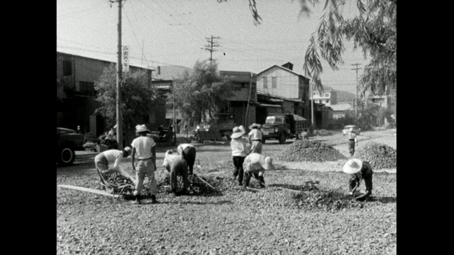 一群日本妇女在用手铺路;1966视频素材