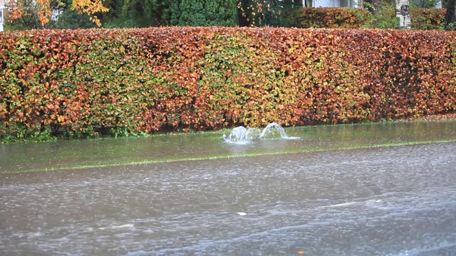 英国坎布里亚郡安布尔赛德市的排水沟里，洪水泛滥，水从井盖上冲了出来。视频素材