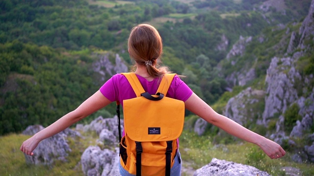 女性徒步旅行者在山顶举起双手。视频素材