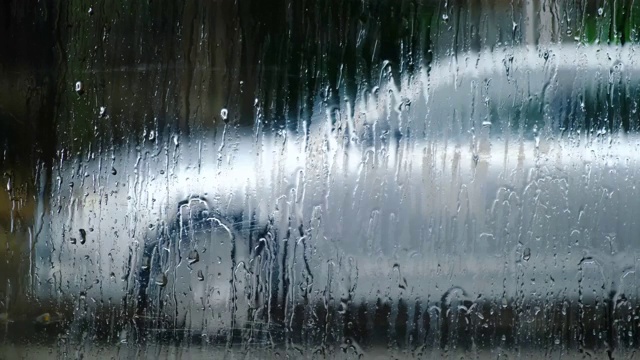 摘要雨天交通。透过车窗与雨滴的道路视图。视频素材