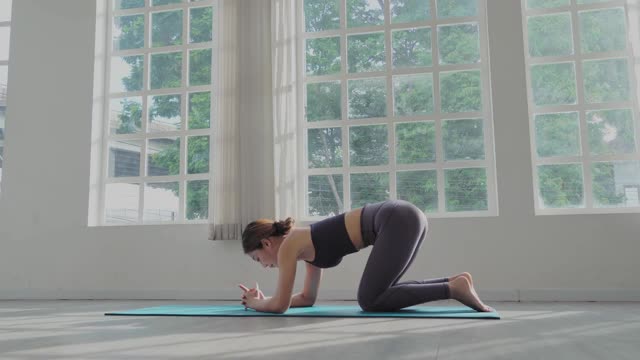 广角镜头:年轻的亚洲运动女性练习瑜伽在垫子上倒立姿势倒立平衡身体在健身室。健康的生活方式视频素材