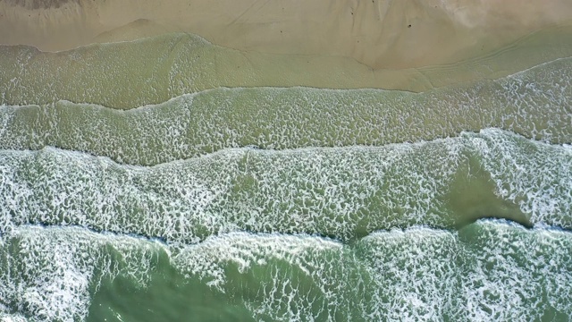 海浪或海浪拍岸。泡沫状的海浪翻滚着涌向沙滩。视频素材