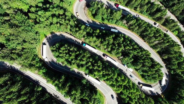 空中鸟瞰蜿蜒的森林道路与发夹弯和移动的交通视频素材