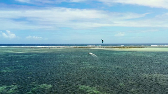 无人机鸟瞰人们在海洋中风筝冲浪。完美的休闲活动在暑假，与海洋的背景在所有的地平线4K视频素材