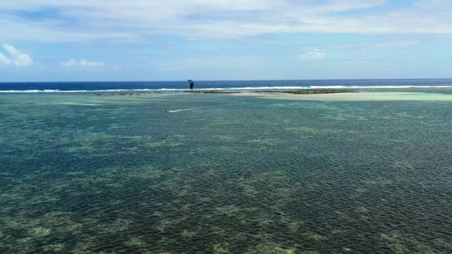 无人机鸟瞰人们在海洋中风筝冲浪。完美的休闲活动在暑假，与海洋的背景在所有的地平线4K视频素材