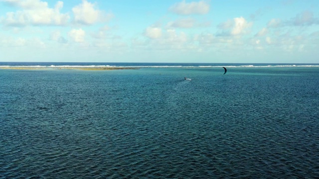 人们在海里做风筝冲浪杂技。完美的休闲活动在暑假，与海洋的背景在所有的地平线-鸟瞰与无人机4K视频素材