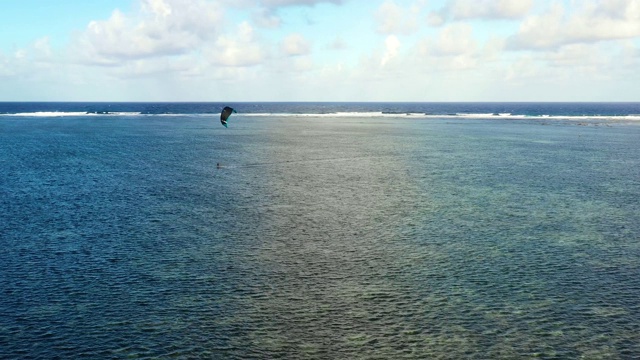 人们在海里做风筝冲浪杂技。完美的休闲活动在暑假，与海洋的背景在所有的地平线-鸟瞰与无人机4K视频素材