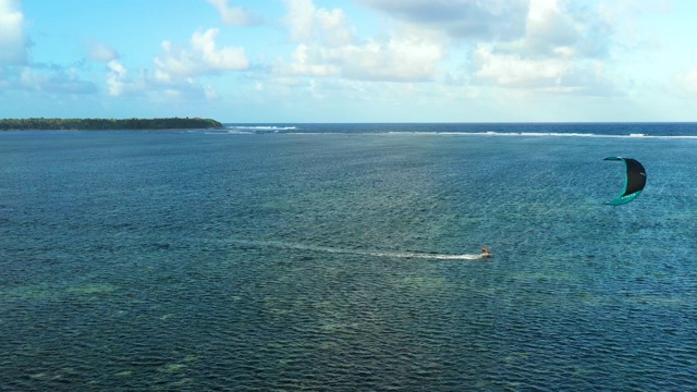 人们在海里做风筝冲浪杂技。完美的休闲活动在暑假，与海洋的背景在所有的地平线-鸟瞰与无人机4K视频素材