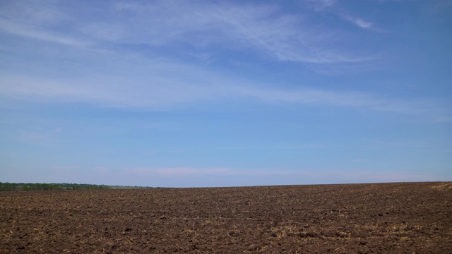 一段时间的耕地和蓝天，晴朗的日子里的土壤和云-农业的概念视频素材