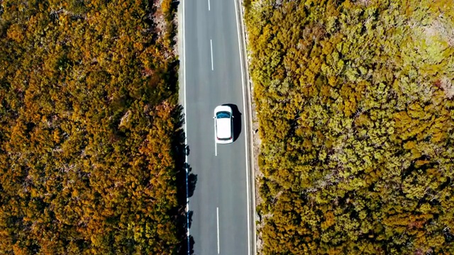 4K无人机拍摄的小白家庭掀背车通过风景如画的风景视频素材