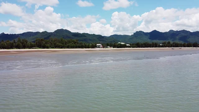 鸟瞰图美丽的海与山脉和棕榈树的背景视频素材