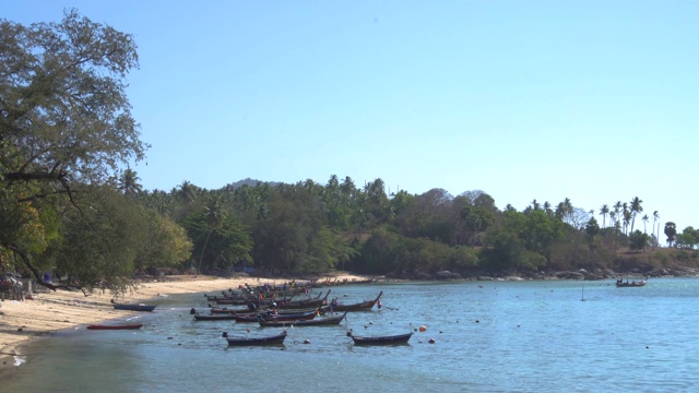 在泰国普吉岛安达曼海的海滩上，当地传统的长尾船配有舷外柴油发动机视频素材