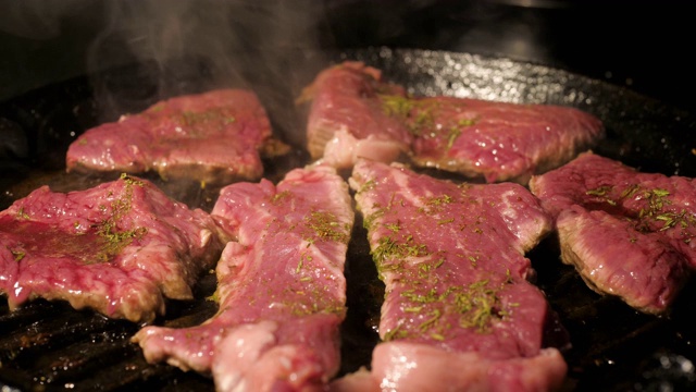 在烧烤锅上烹饪牛排生肉的特写视频素材