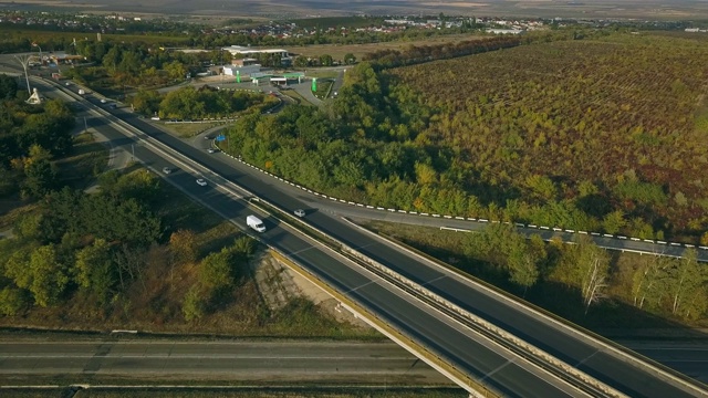 鸟瞰图飞行在令人惊叹的秋天自然和道路运行通过风景如画的乡村。路在秋景航拍。秋日的汽车驾驶道路穿过五彩缤纷的风景。视频素材