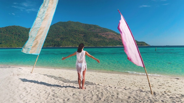 年轻女子与手放松和享受绿松石海在热带海滩天堂岛视频素材