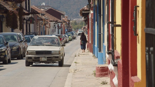 墨西哥恰帕斯的圣克里斯托巴尔德拉斯卡萨斯(San Cristobal de las Casas)，狭窄的街道两旁排列着殖民风格的房屋视频素材